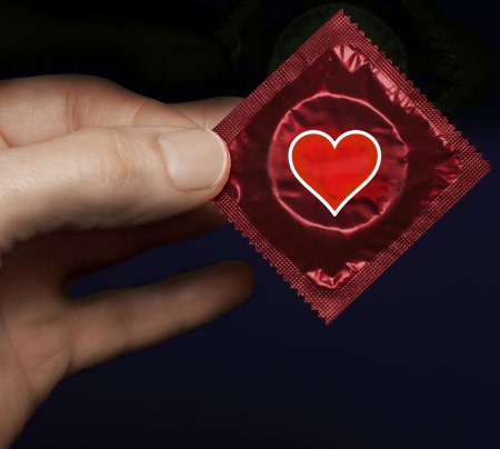 Man's-hand-with-a-red-condom-pack-and-heart-symbol-000051974822_Medium.jpg