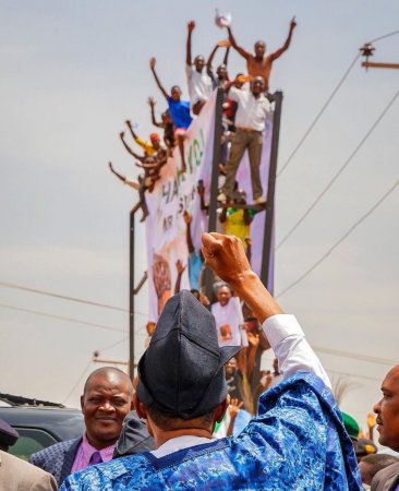 photos-of-young-men-who-climbed-billboard-just-to-see-president-buhari-in-plateau-go-viral.jpg