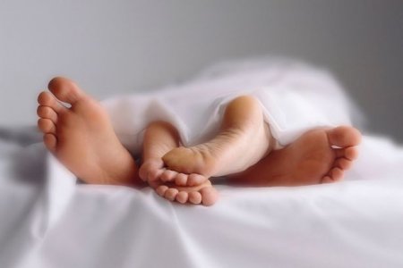 Couple-in-bed-close-up-of-feet-entwined.jpg