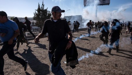 Central American migrants flee tear gas near a U.S.-Mexico border.jpg