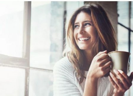 lady with a cup smiling.JPG