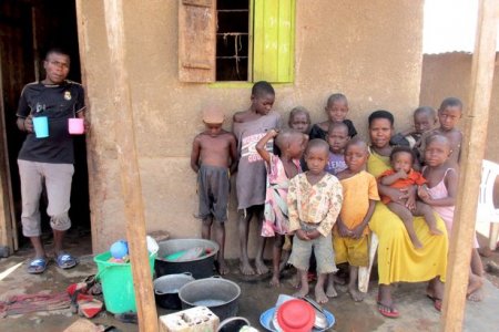 0_PAY-The-Ugandan-woman-Mariam-Nabatanzi-sits-in-front-of-the-house-with-13-of-her-children-in...jpg