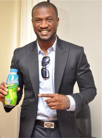 Peter Okoye holding a bottle of Olympic Milk.jpg