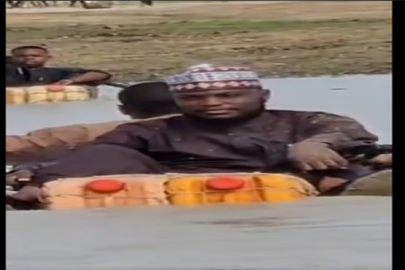 [VIDEO] Kogi LGA Chairman Goes Viral for Paddling on Kegs Through Flood