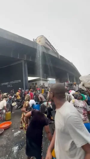 [VIDEO] Lagos Residents Risk Lives Scooping Fuel from Overturned Tanker on Apapa Bridge